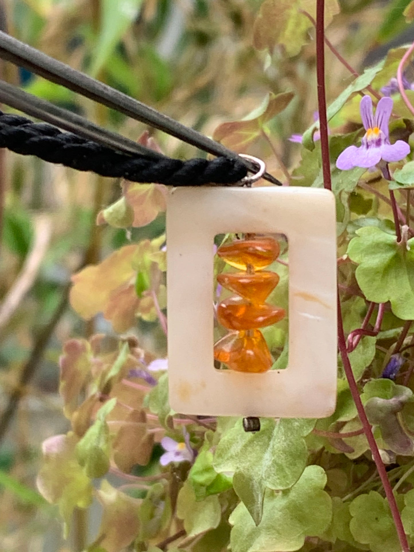 Amber and mother-of-pearl, pendant measuring 31x17x9 millimeters, sold with a sliding (adjustable) black leather cord measuring 40 to 70 centimeters!