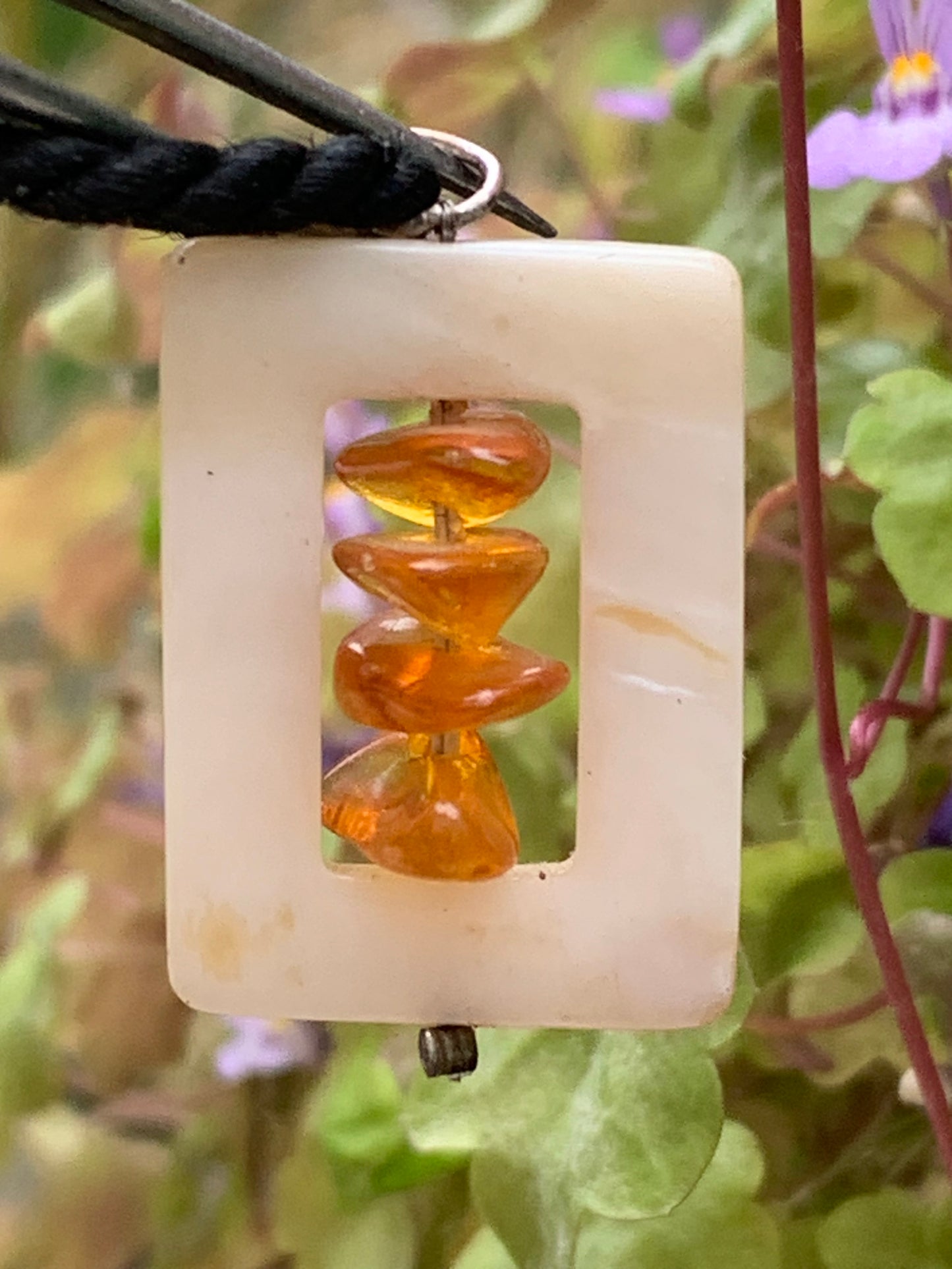 Amber and mother-of-pearl, pendant measuring 31x17x9 millimeters, sold with a sliding (adjustable) black leather cord measuring 40 to 70 centimeters!