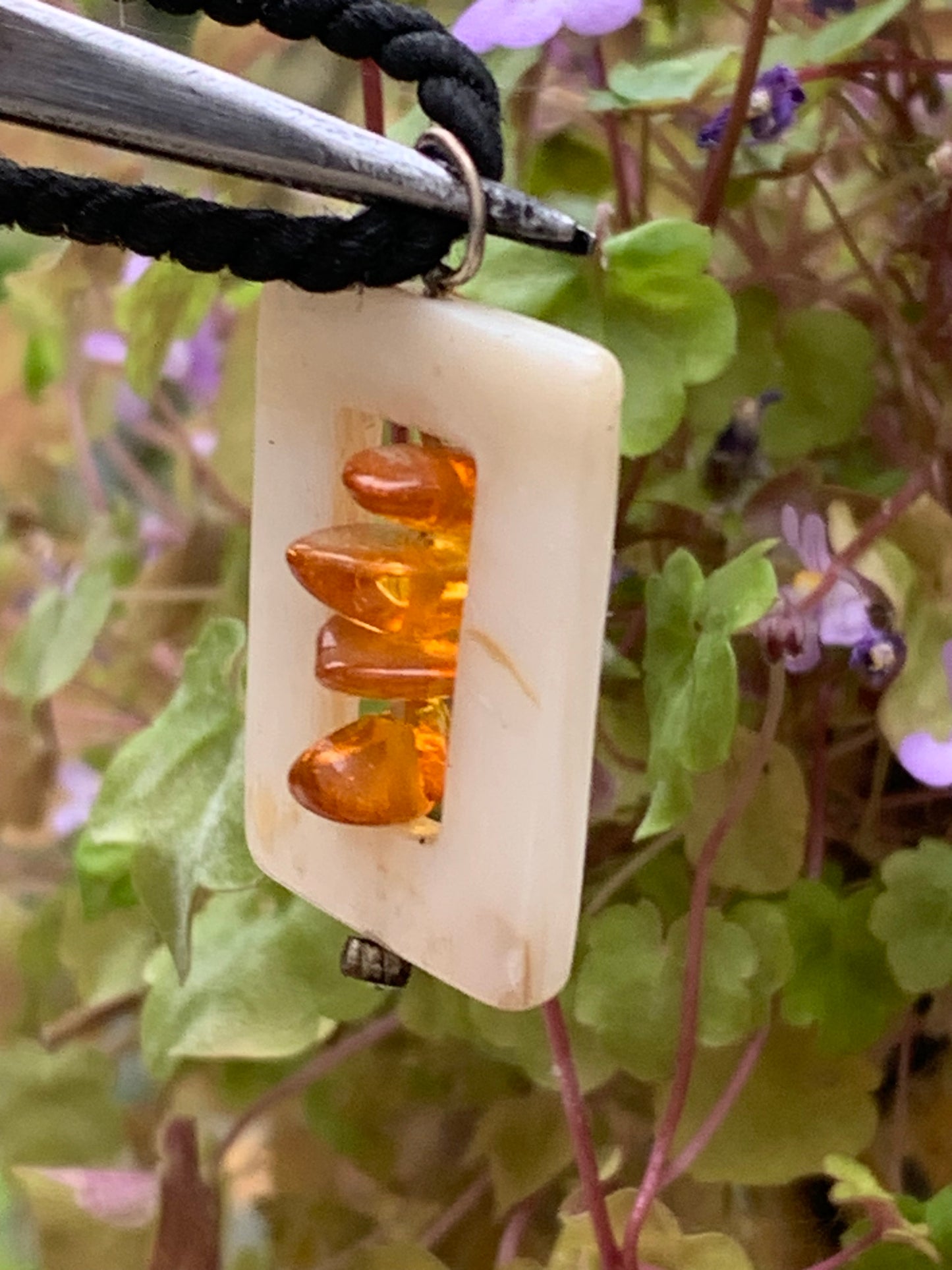 Amber and mother-of-pearl, pendant measuring 31x17x9 millimeters, sold with a sliding (adjustable) black leather cord measuring 40 to 70 centimeters!