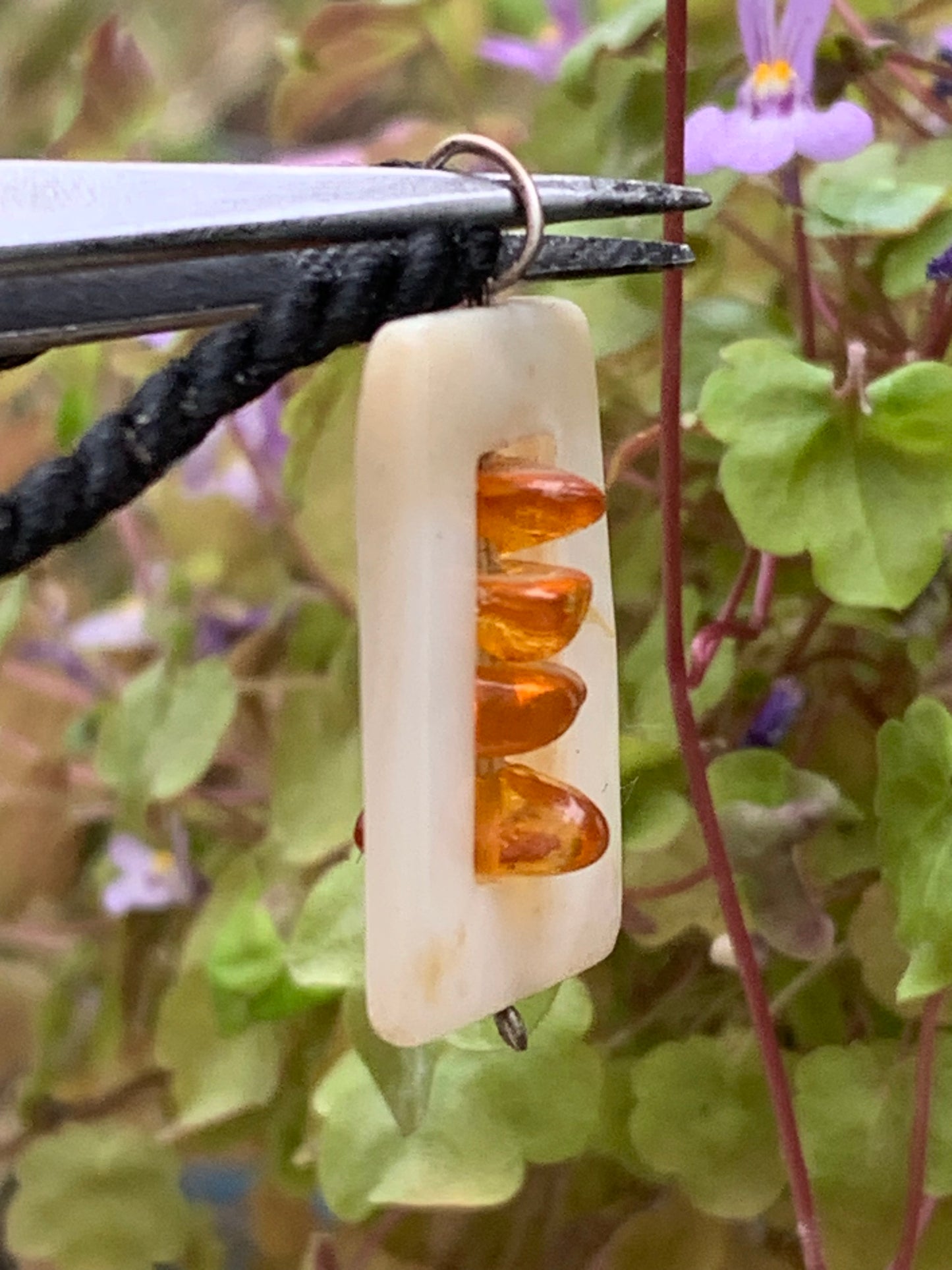 Amber and mother-of-pearl, pendant measuring 31x17x9 millimeters, sold with a sliding (adjustable) black leather cord measuring 40 to 70 centimeters!