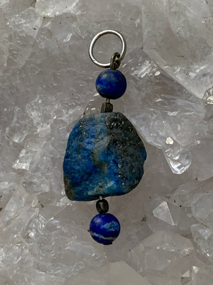 Lapis lazuli, pendentif en Argent 925, pièce brute avec 2 perles, de 46 millimètres de hauteur x 15 millimètres de largeur x 12 d'épaisseur. Vendu avec un cordon réglable de couleur noire !