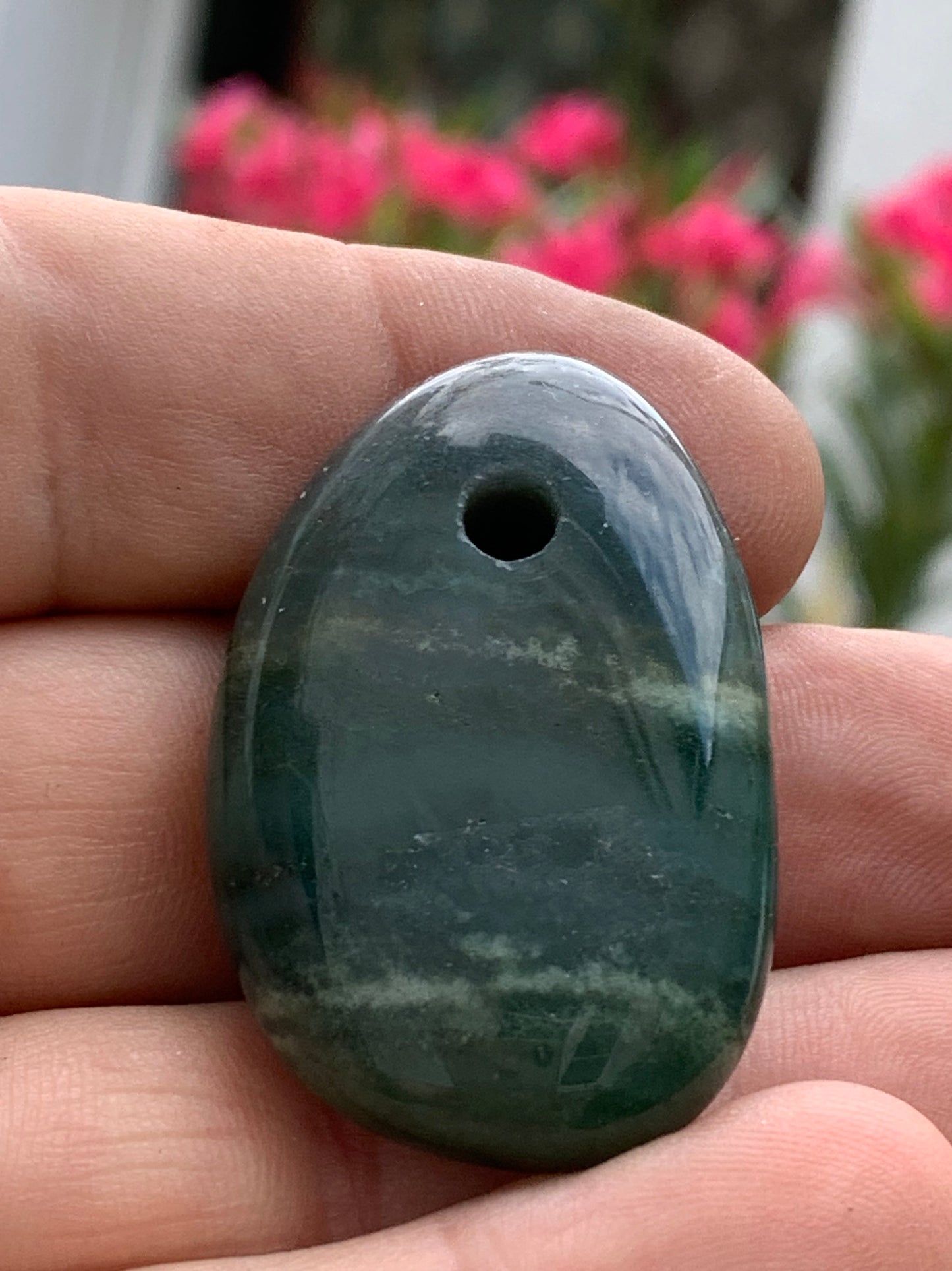 Jade, galet percé 43 mm de hauteur x 30 de largeur x 12 d'épaisseur. Vendu avec cordon réglable de couleur noire.
