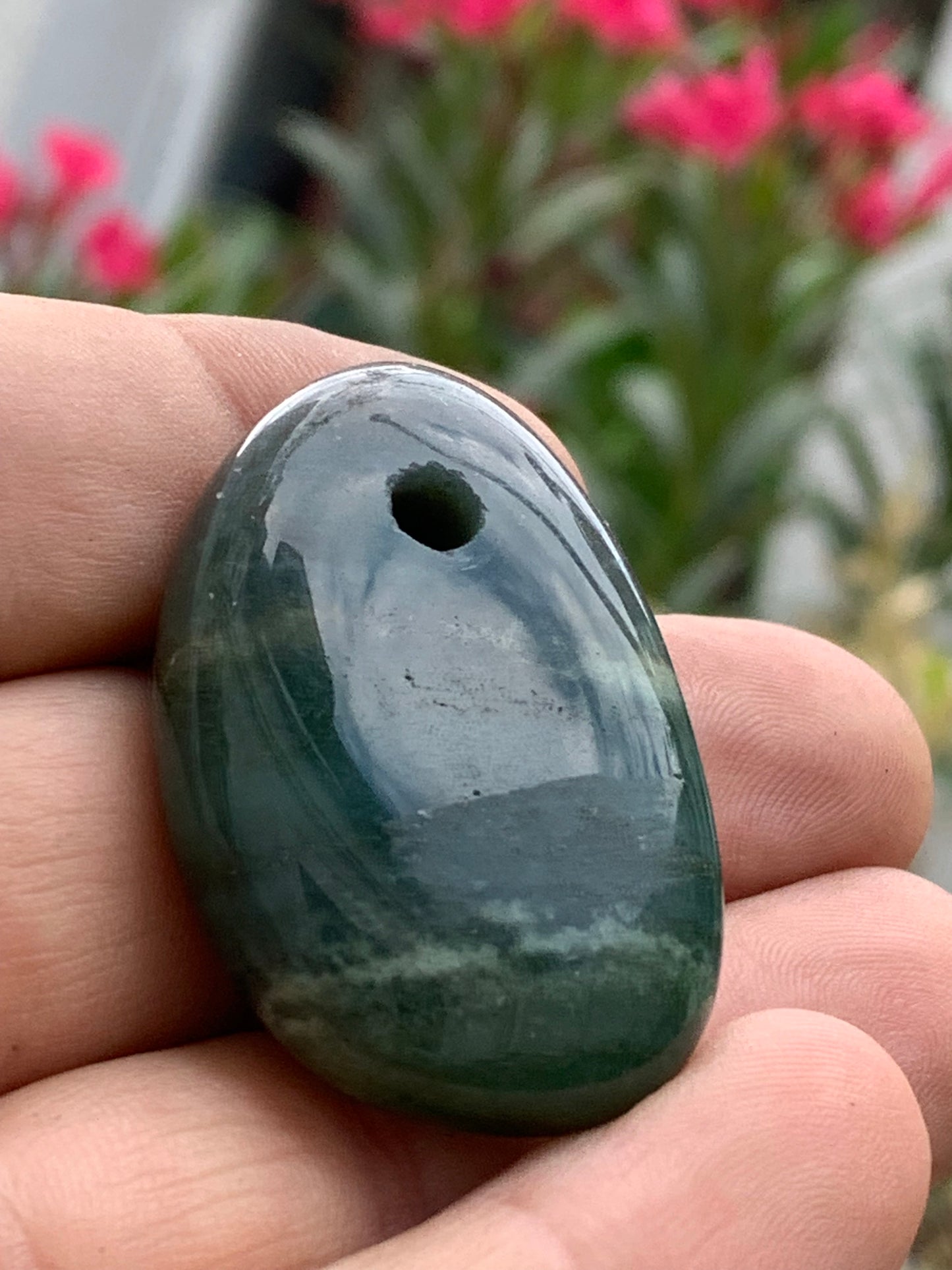 Jade, galet percé 43 mm de hauteur x 30 de largeur x 12 d'épaisseur. Vendu avec cordon réglable de couleur noire.