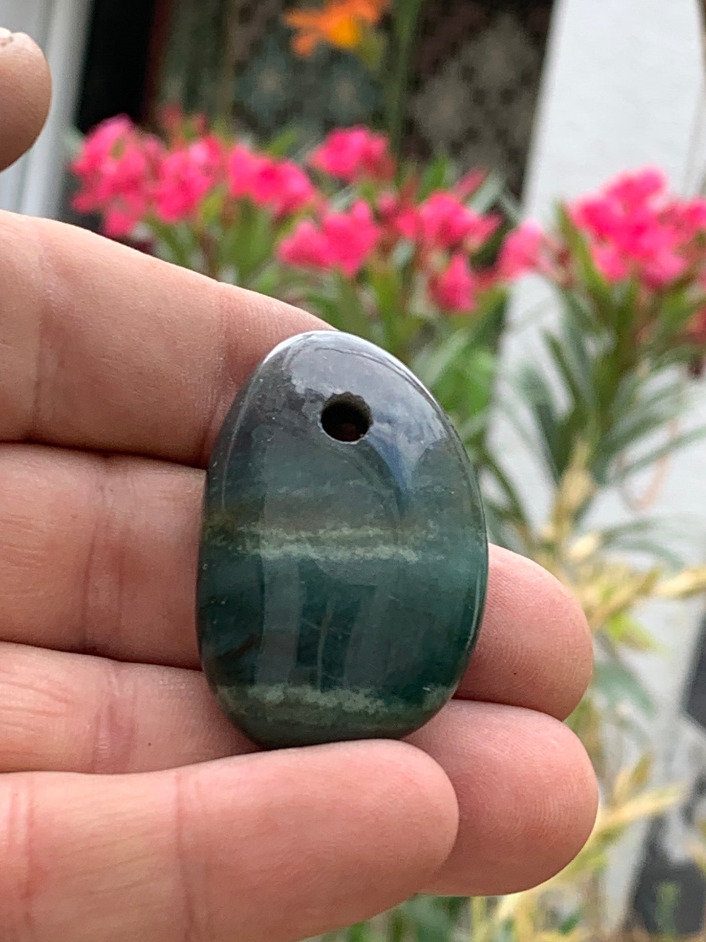 Jade, galet percé 43 mm de hauteur x 30 de largeur x 12 d'épaisseur. Vendu avec cordon réglable de couleur noire.