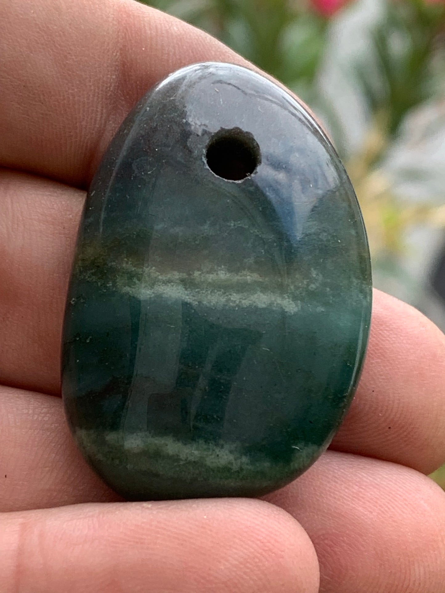 Jade, galet percé 43 mm de hauteur x 30 de largeur x 12 d'épaisseur. Vendu avec cordon réglable de couleur noire.