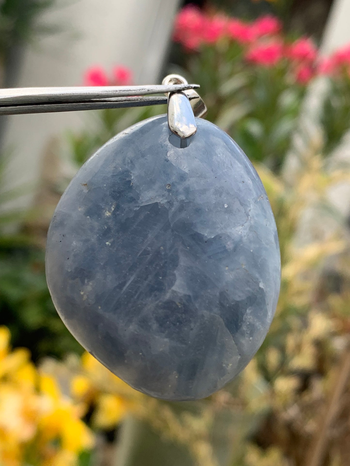 Blue calcite, pendant measuring 47mm high x 37mm wide x 18mm deep. Sold with an adjustable black cord!