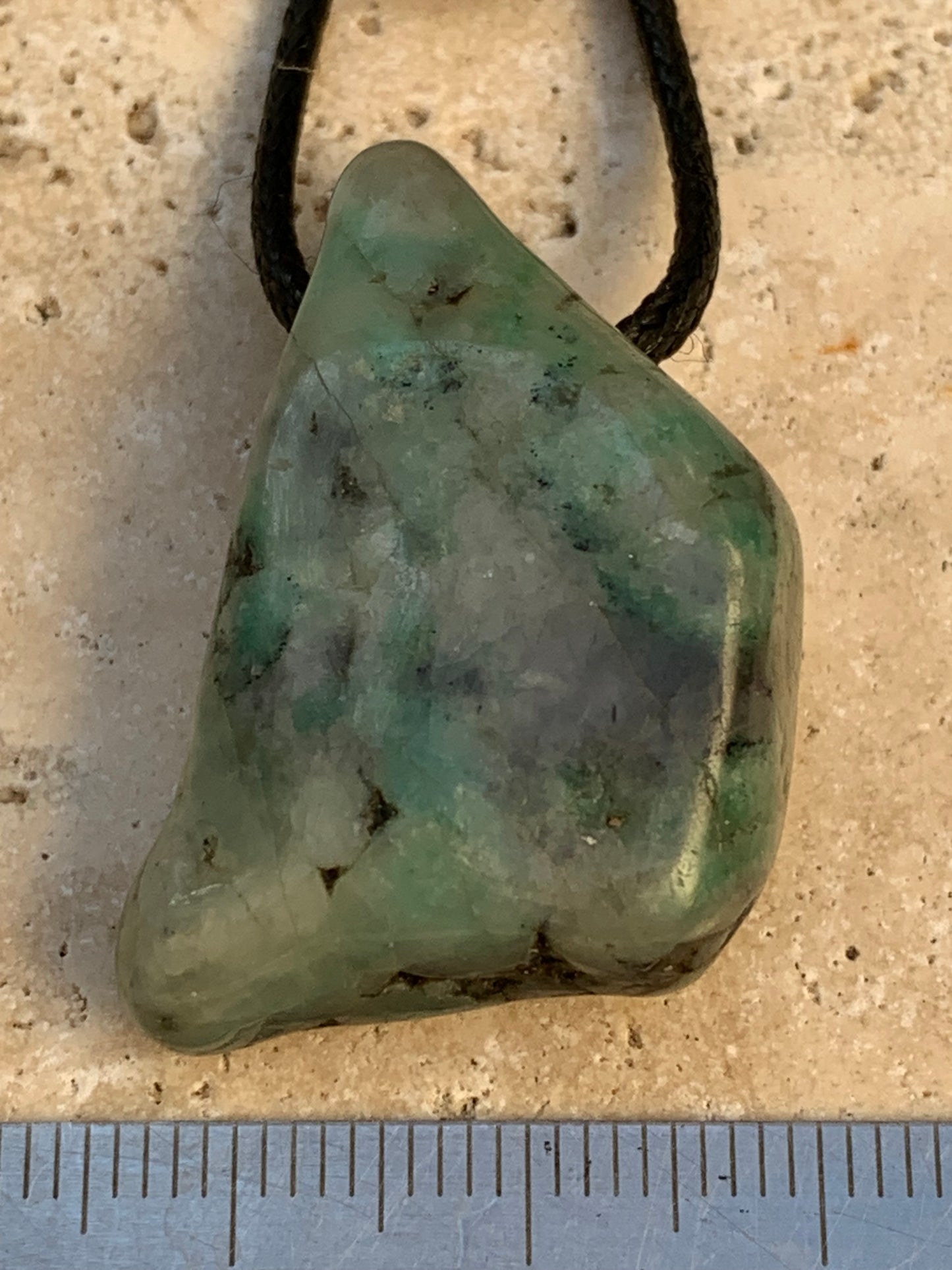 Émeraude, pierre brute percée de 33mm x21 x12 - 12,4 grammes. Vendu avec cordon noir réglable !