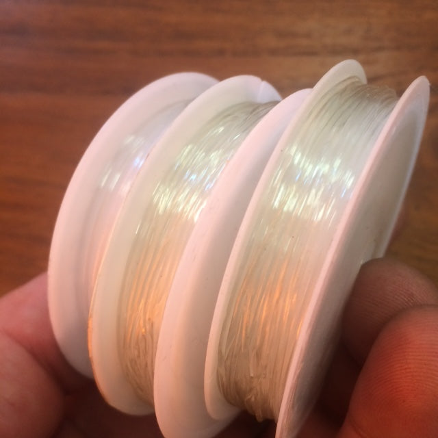 Sélection de fils divers 'spécial bijouterie' : Fil élastique transparent 8mm ou 10mm, ou couleurs 8mm. Bobine de fil en cordon de coton ciré noir de 15mm (bobine de 7 ou 450m.) !