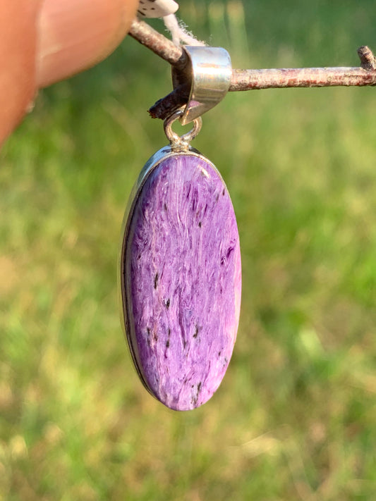 Charoite, pendant set in solid silver measuring 50mm x 17 x 8. Sold with adjustable black cord, ready to wear!