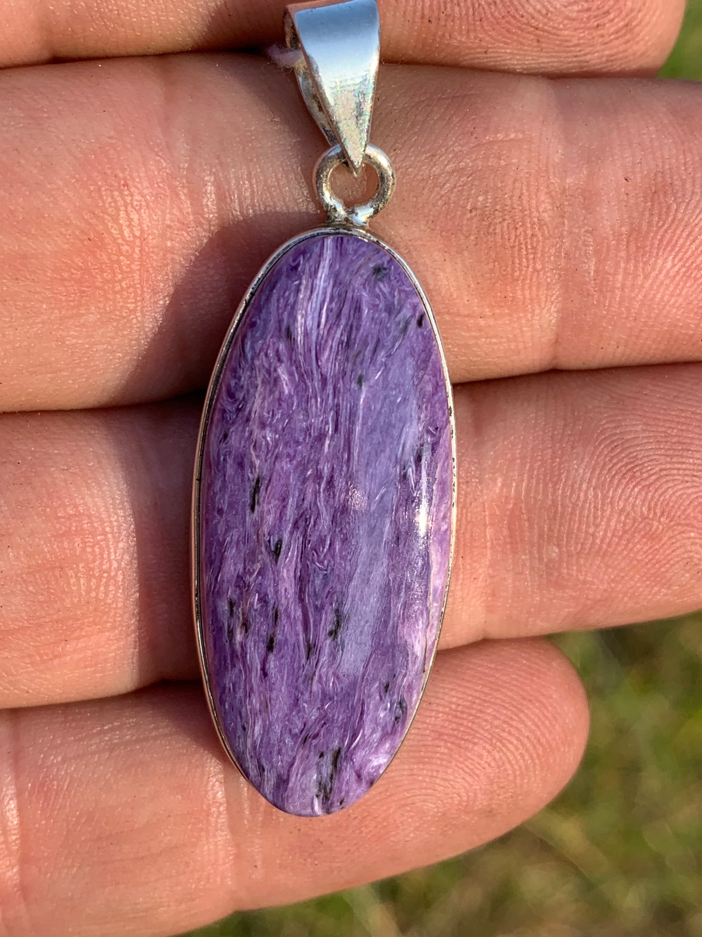 Charoite, pendant set in solid silver measuring 50mm x 17 x 8. Sold with adjustable black cord, ready to wear!