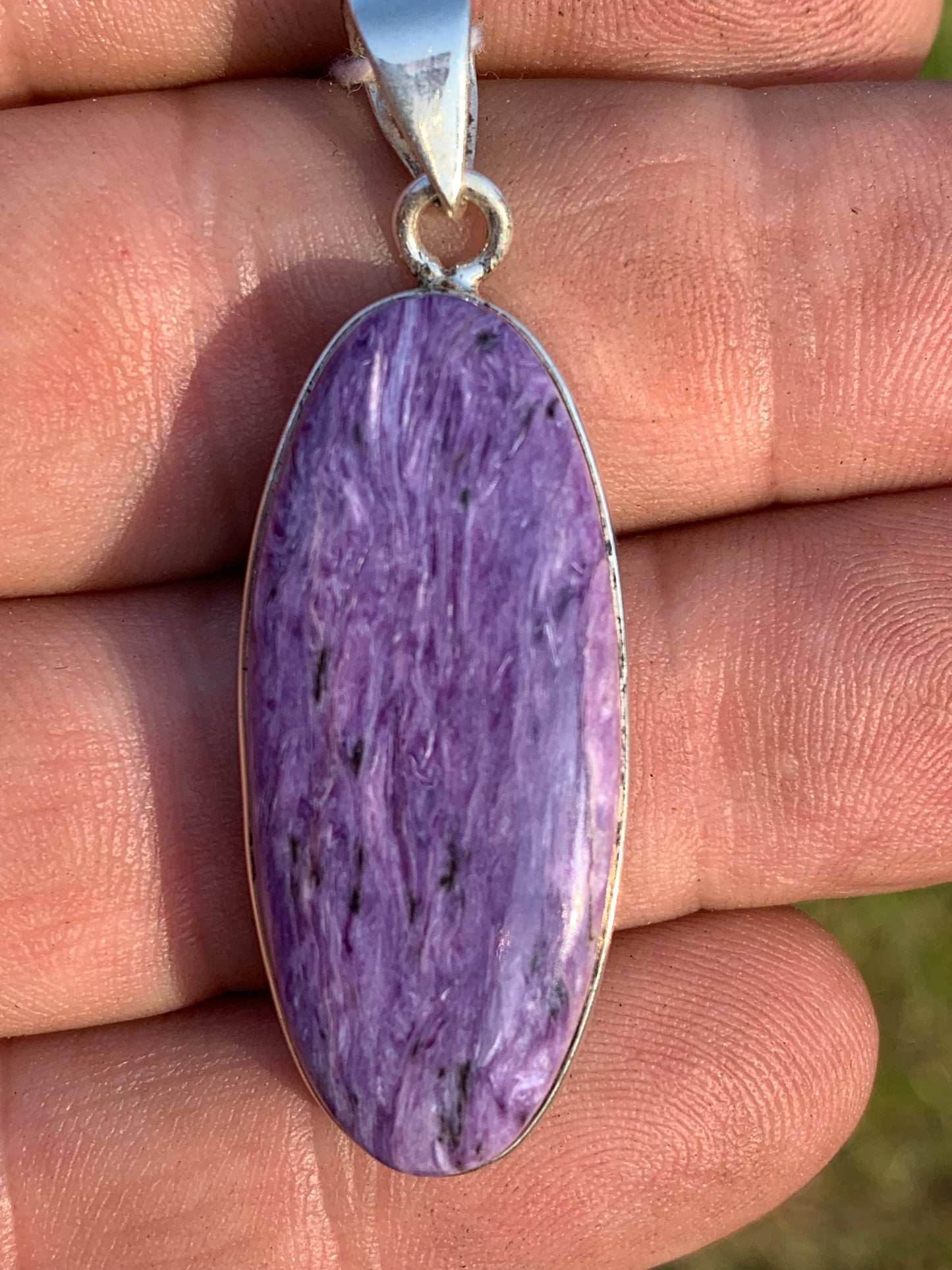 Charoite, pendant set in solid silver measuring 50mm x 17 x 8. Sold with adjustable black cord, ready to wear!