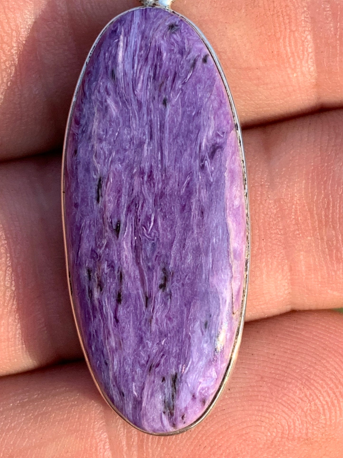 Charoite, pendant set in solid silver measuring 50mm x 17 x 8. Sold with adjustable black cord, ready to wear!