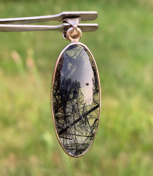 Rock crystal/quartz with black tourmaline inclusions! Silver pendant, 45mm high x15 x8. Sold with adjustable black cord!