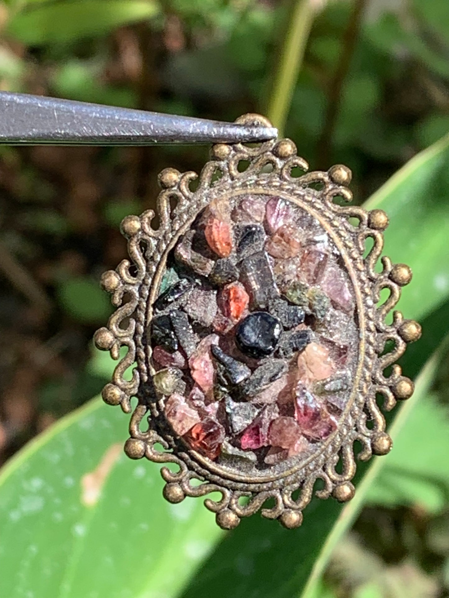 Médaillon couleur Bronze avec Tourmaline multicolore, de 36 mm de ht x30 x 8. Vendu avec un cordon noir réglable !