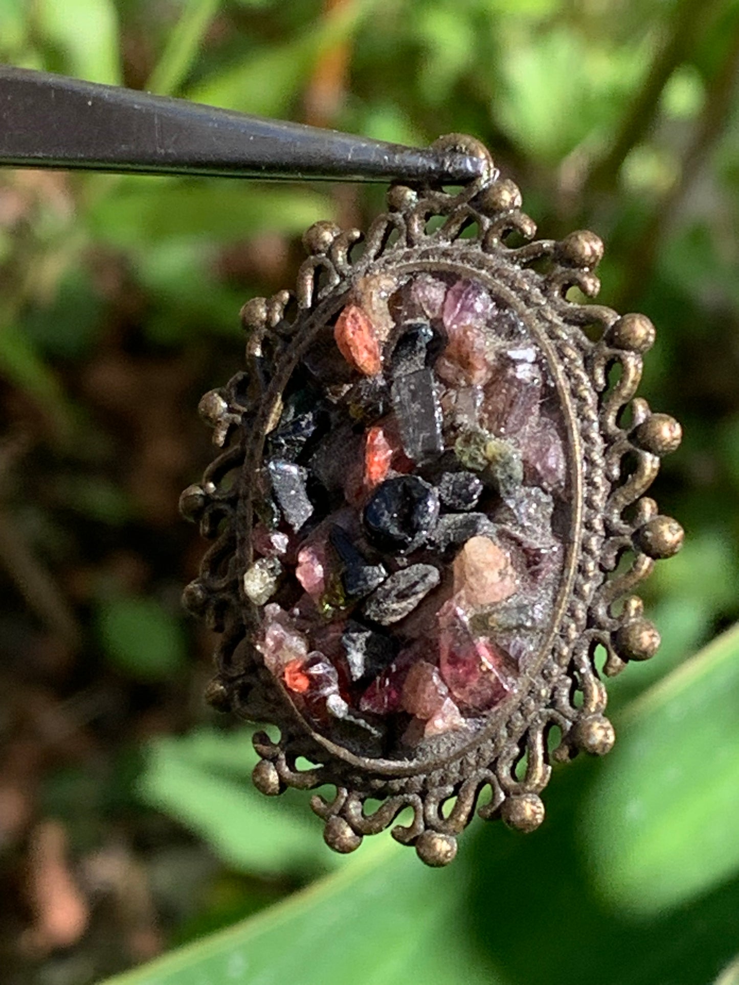 Médaillon couleur Bronze avec Tourmaline multicolore, de 36 mm de ht x30 x 8. Vendu avec un cordon noir réglable !