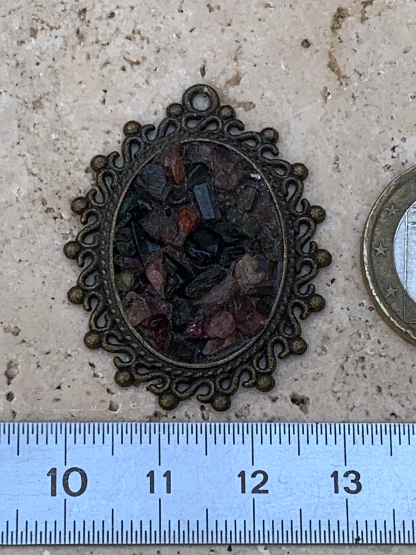 Médaillon couleur Bronze avec Tourmaline multicolore, de 36 mm de ht x30 x 8. Vendu avec un cordon noir réglable !