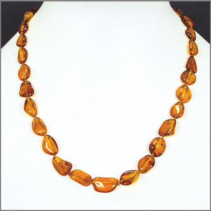 Cognac-colored amber, free-form, natural beads measuring 15 to 20 millimeters, sold in a 45 to 50 centimeter necklace. Amber screw clasp system. AA to AAA quality, superb beads, lightweight and incredibly soft!