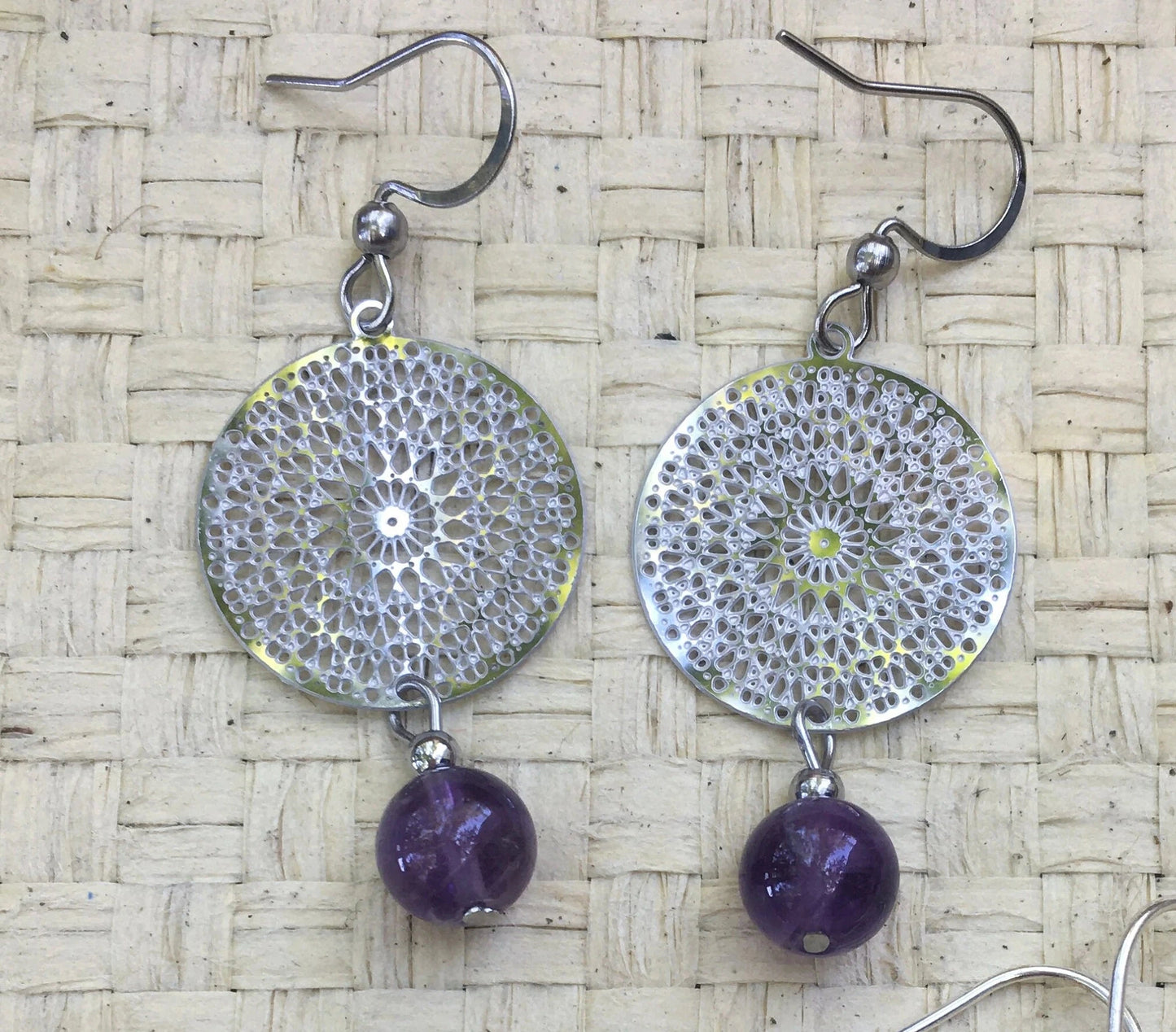 Boucles d'oreilles en Améthyste avec un superbe Mandala en Argent où est suspendue une perle ronde, qualité AA à AAA. Vendu en finition Argent 0.925, parfait !